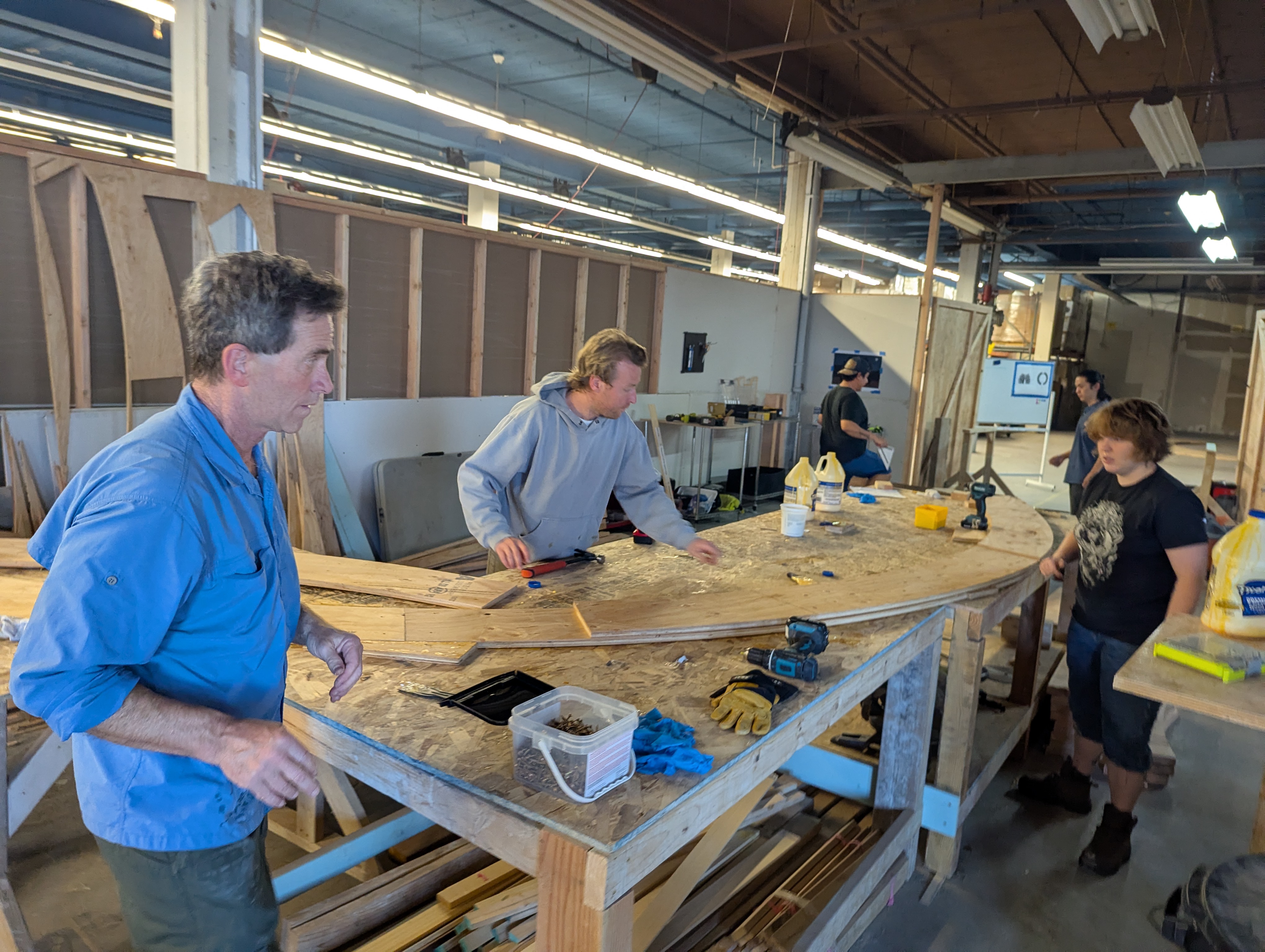 Team members working together around a build table